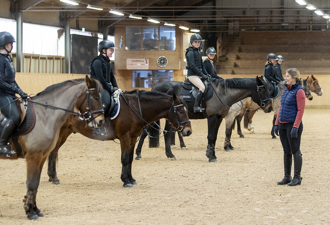 Personal hjälper elev att hoppa upp på ponny.